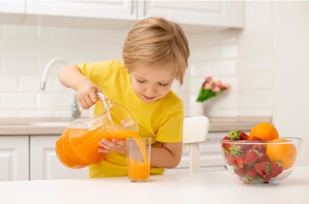 Anak Menuang Orange Jus dalam Gelas