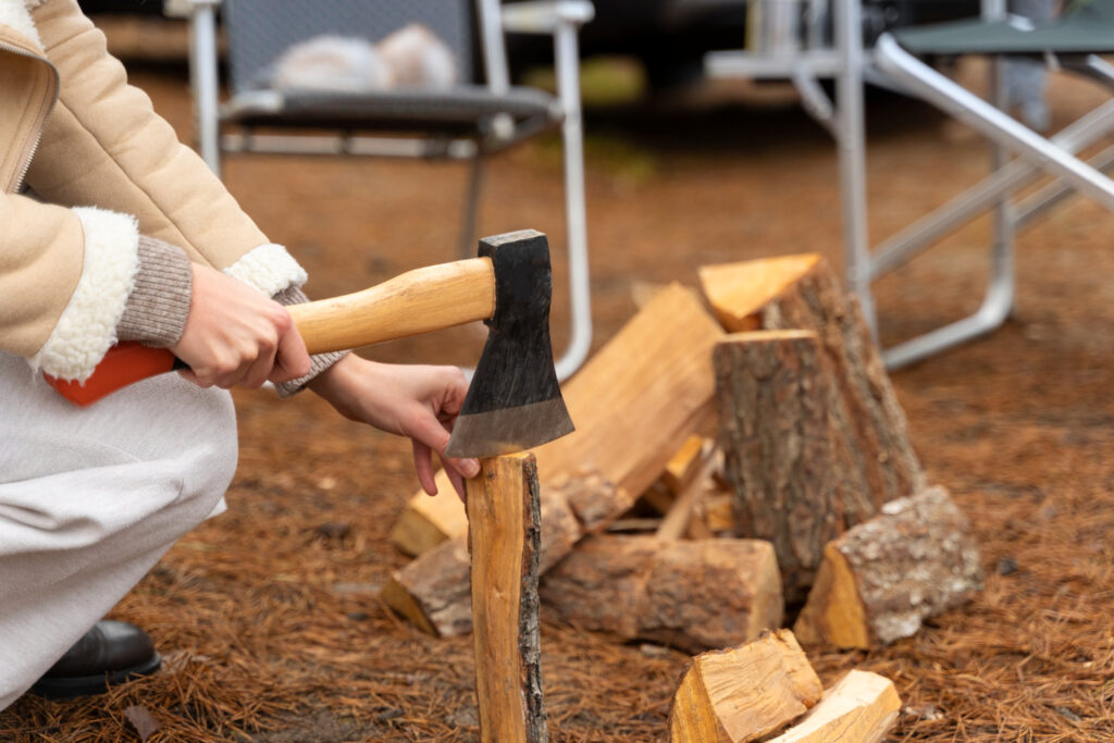 woman chopping wood with axe bonfire