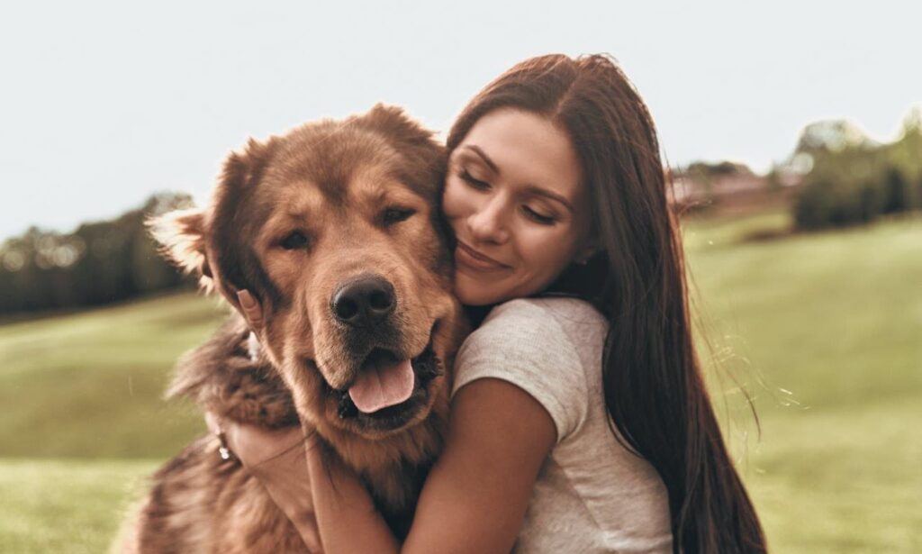 Perempuan memeluk anjing sebagai bentuk rasa sayang
