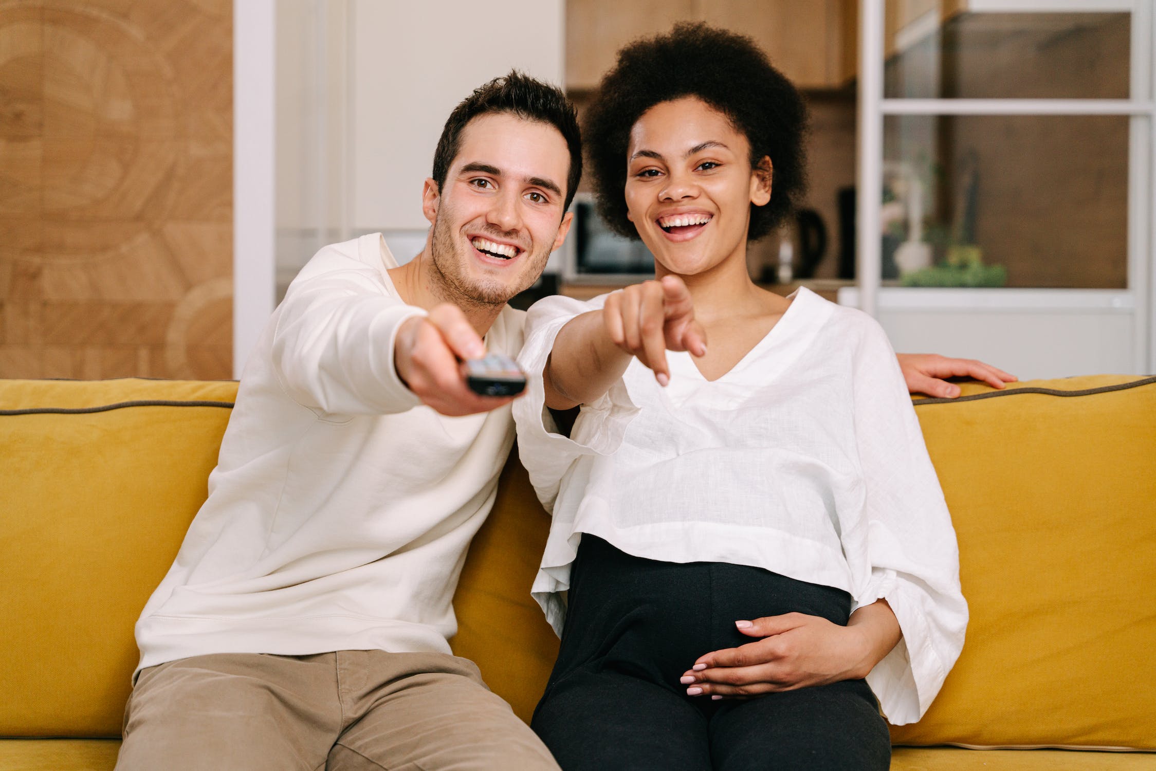 Dua pasangan duduk di sofa sambil tersenyum